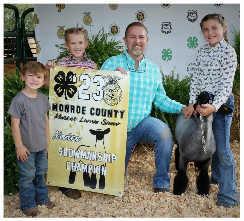 Tyner Dunn olivia harris with banner chad sanders and emmalyn jeremias with lamb named Georgia